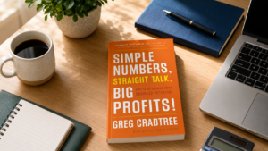 Simple Numbers, Straight Talk, Big Profits by Greg Crabtree — book with coffee, notebook, and pen on a desk